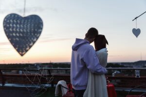 boy-girl-hug-each-other-tender-standing-rooftop-rays-evening-lights (1)